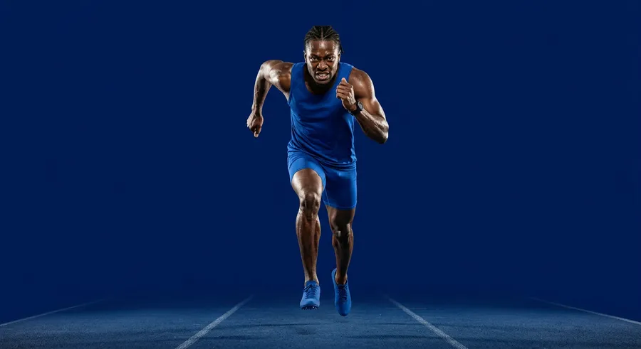 Sprinter in navy kit driving forward at speed